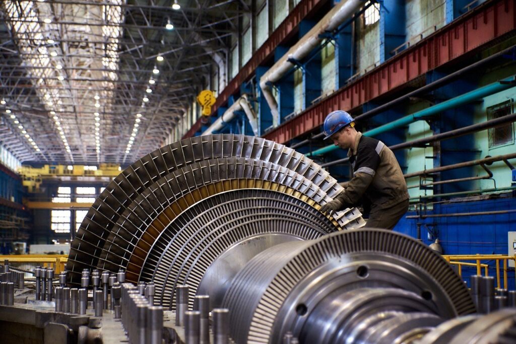 Steam turbine rotor with multiple rows of blades during assembly in an industrial workshop.