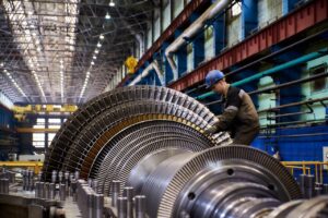 Steam turbine rotor with multiple rows of blades during assembly in an industrial workshop.